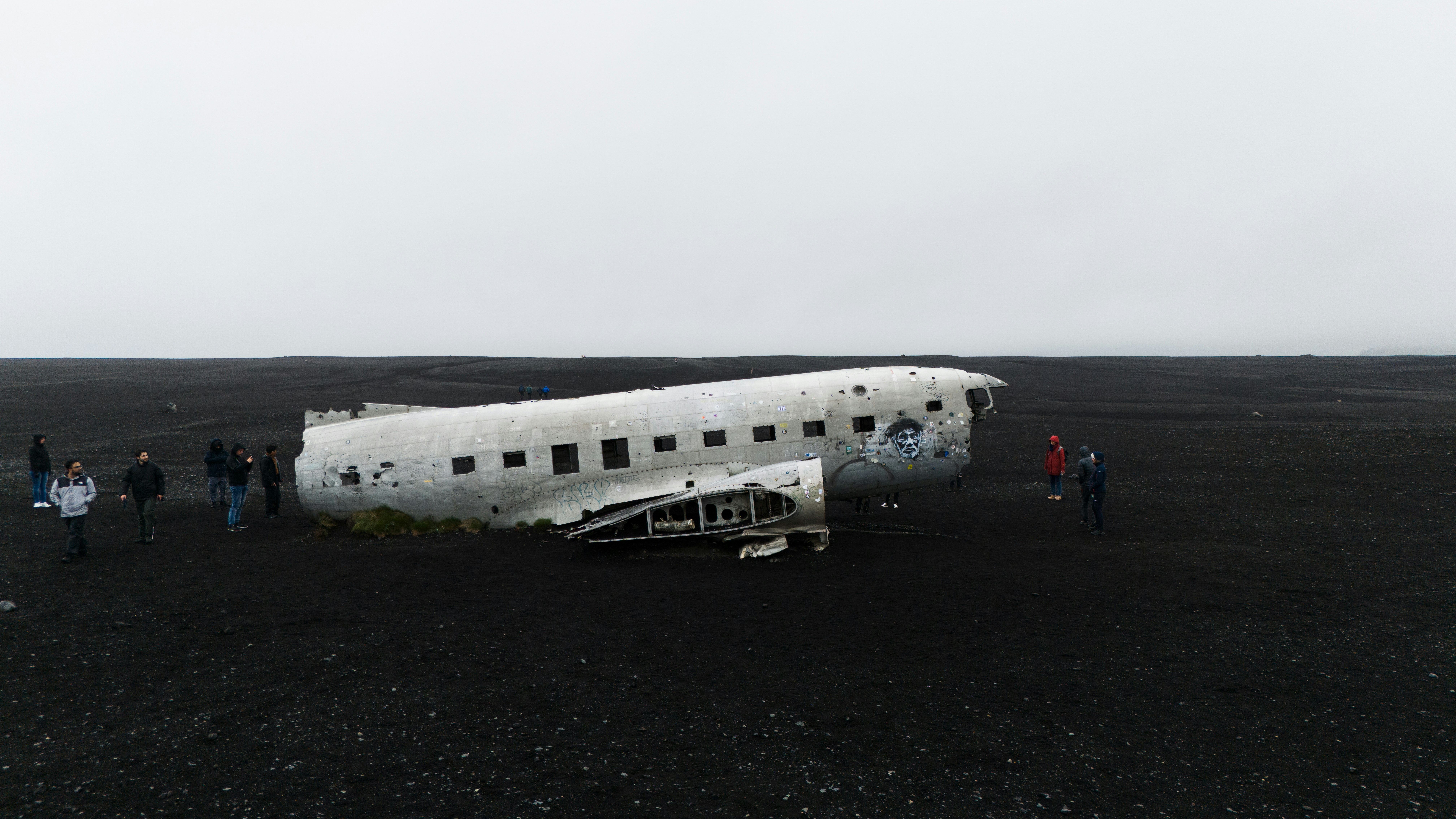 a group of people standing around an old airplane